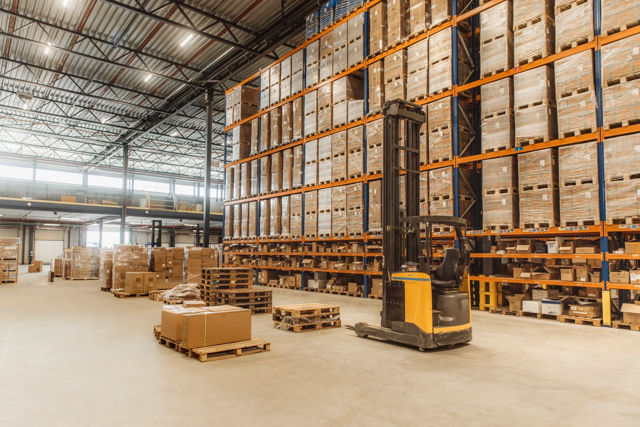 Warehouse aisle with high racks and a forklift
